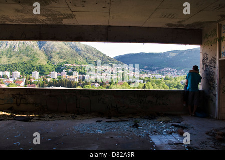 Paar Kuss im Graffiti bedeckt Krieg beschädigt Stara Banka Staklena Gebäude In Mostar Stockfoto