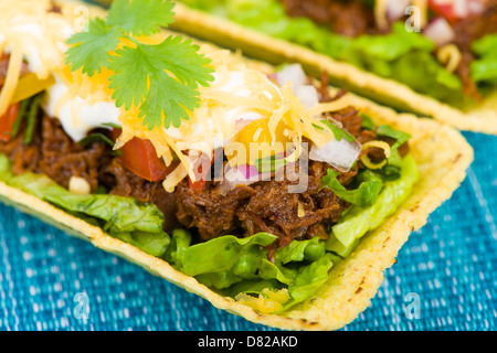 Rindfleisch Tacos - Hackfleisch-Taco-Schalen garniert mit Salsa, saure Sahne und geriebenem Käse. Stockfoto