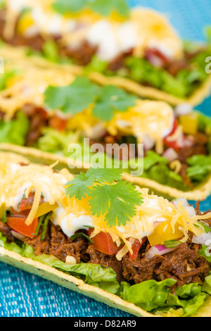 Rindfleisch Tacos - Hackfleisch-Taco-Schalen garniert mit Salsa, saure Sahne und geriebenem Käse. Stockfoto