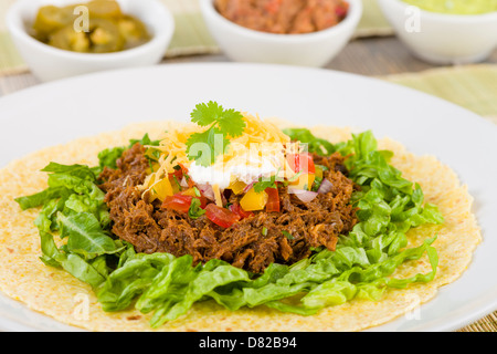Rindfleisch Tacos - mexikanische zerkleinert Rindfleisch Tacos in weiche Maistortillas, serviert mit Salat, Sauerrahm, geriebener Cheddar-Käse und salsa Stockfoto
