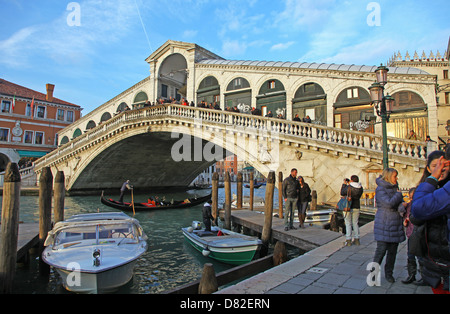 Eine Gondel und Gondoliere Rudern gehen unter der Rialto-Brücke mit Touristen fotografieren Canal Grande Venedig Italien Stockfoto