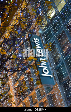 John Lewis Zeichen unter Weihnachtsschmuck auf der Oxford Street Store mit Herbst Blätter West End London England Großbritannien Stockfoto