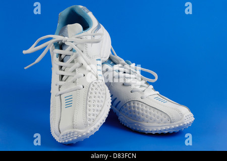 Paar weiße Damen leichte atmungsaktive Laufschuhe, Turnschuhe auf blauem Hintergrund isoliert Stockfoto