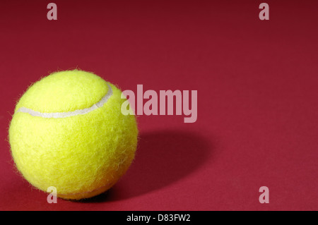 Nahaufnahme eines Tennisballs isoliert auf rotem Grund Stockfoto