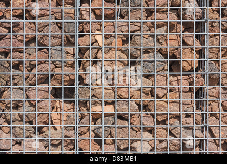 Gabion Wand gefüllt mit Lavasteinen in der Sonne Stockfoto