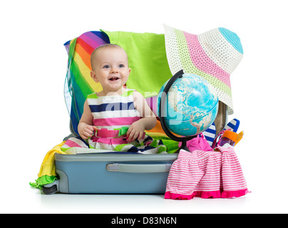 Babymädchen sitzen im Koffer mit Dingen für Urlaubsreisen Stockfoto