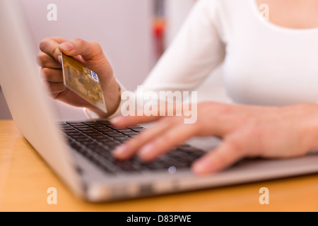 Weiblich, Einkaufen im Internet mit ihrem Laptop zu tun Stockfoto