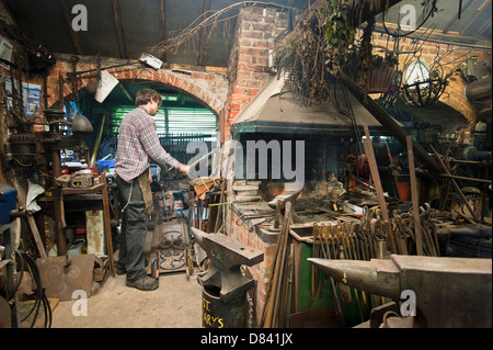 Schmied in eine traditionelle Schmiede arbeiten. Stockfoto