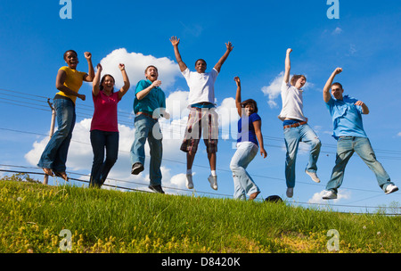 Eine Gruppe von verschiedenen College-Studenten/Freunde springen in die Luft draußen auf einem Hügel Stockfoto