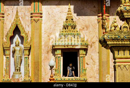 PHUKET, THAILAND 15. Mai 2013: Frau blickt Fenster der Hauptstupa, Wat Chalong Stockfoto