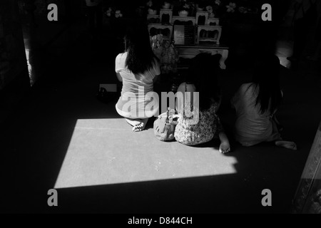 PHUKET, THAILAND Mai 15 2013:Three Thai Frauen kniend verrichten Wai Phra - Buddhist bietet - im Wat Chalong. Stockfoto