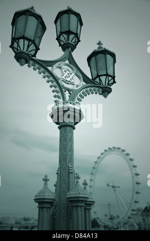 Eine reich verzierte Straßenlaterne auf Westminster Bridge mit London Eye in der Ferne, London. Stockfoto