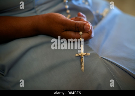 Menschen und Religion, katholische Schwester in der Kirche beten und Kreuz in den Händen halten. Mit Model-release Stockfoto