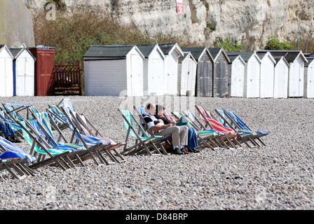 Ein paar sitzen in Liegestühlen genießen das britische Sonnenwetter Bier Devon England uk Stockfoto