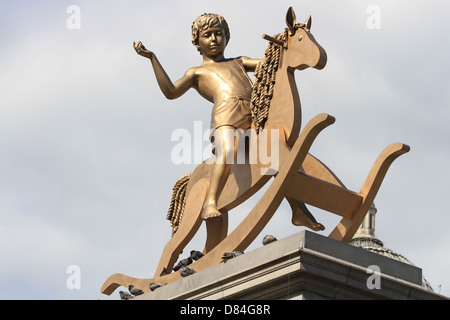 Designed by Michael Elmgreen und Ingar Dragset. Mit dem Titel "Machtlos Structures", eine hohe Bronze-Skulptur eines jungen auf Schaukelpferd Stockfoto