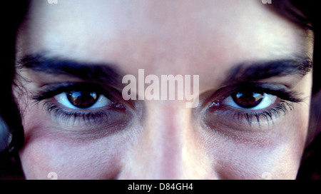 Eine extreme Nahaufnahme von den faszinierenden braunen Augen eines attraktiven Mädchen in ihren Zwanzigern, die hat auch lange Wimpern und dicken dunklen Augenbrauen. Stockfoto