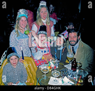 Vier glückliche Kinder begleiten Sie ihre Eltern um party und feiern Silvester im Jahr 1975 in der Lounge ein Resort-Hotel in Palm Springs, Kalifornien. Stockfoto