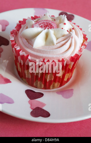 Erdbeeren und Sahne Cupcake am Herzen Platte auf rosa Hintergrund festlegen Stockfoto