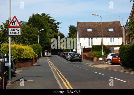 Ältere Menschen, die Straße überqueren zu unterzeichnen, im Wohngebiet, Southborough, Tunbridge Wells, Kent, England Stockfoto