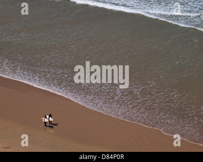 Zwei Surfer am Strand entlang im Watergate Bay, Cornwall, UK 2013 Stockfoto