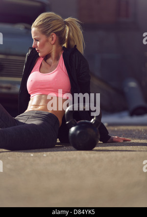 Attraktive Frauen sitzen auf der Straße und Erholung nach dem Training Stockfoto