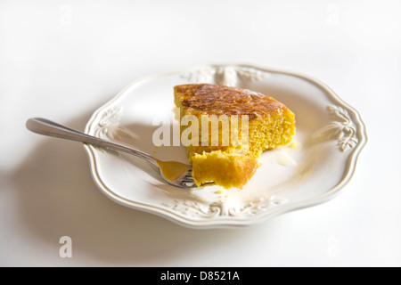 Ein Stück hausgemachtes Maisbrot auf einem weißen Teller mit weißem Hintergrund. Gabel enthalten. Oklahoma, USA. Stockfoto