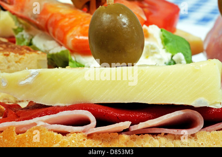 Spanische Tapas-Auswahl, Boliled Schinken, Paprika und Käse garniert mit grünen Oliven und auf knusprigem Brot serviert. Stockfoto