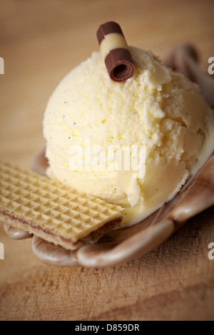 Hausgemachtes Vanilleeis mit Waffel und Dekoration in eine Schüssel geben Stockfoto