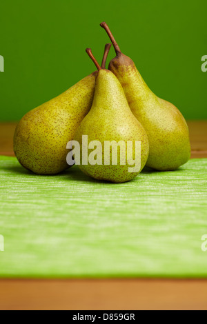 Drei Birnen vor einem grünen Hintergrund angeordnet Stockfoto
