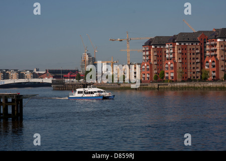 Krane auf Bauarbeiten in der Nähe von Battersea Heliport und Wandsworth Brücke mit Thames River bus Stockfoto