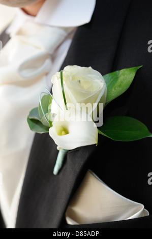 Bräutigam mit weißen Rosen und weiße Lilie im Knopfloch. Stockfoto