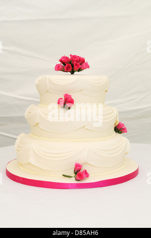 Hochzeitstorte an der Rezeption mit rosa Details. Stockfoto