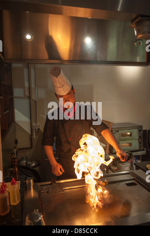 Asiatischen männlichen Teppanyaki-Koch bei der Arbeit in einer Restaurantküche. Stockfoto