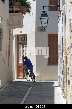 Ein einsamer Radfahrer rundet eine Biegung innerhalb einer Gasse in der Altstadt von Rethymno, Crete Stockfoto