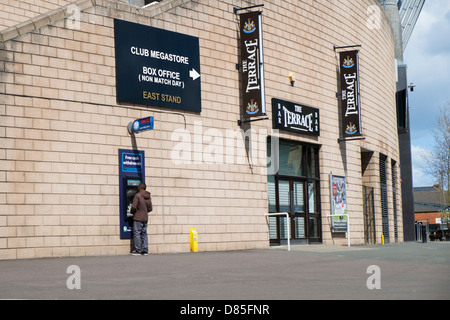 Ein Mann an einen Punkt Geldautomaten im St James Park Stadium. Stockfoto