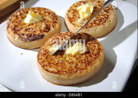 Butter mit einem Messer auf einen heißen geröstetem Fladen zu verbreiten, zum Frühstück oder Tee Stockfoto