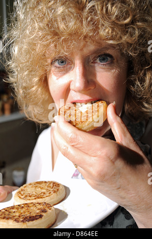 Frau genießen eine heiße gebutterte Fladen zum Frühstück oder Tee Essen Stockfoto