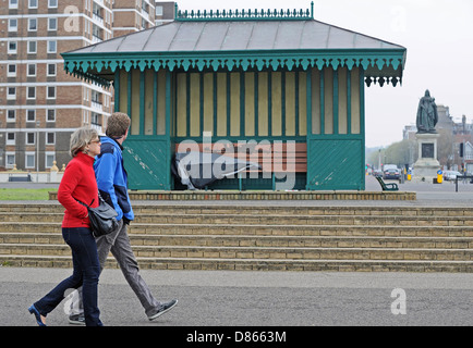 Hove Sussex UK gehen 19. Mai 2013 - ein paar vorbei an einem Mann schlafen rau in einem Tierheim auf Hove direkt am Meer Stockfoto