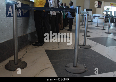 Passagiere Schlange hinter Gurtabroller Beiträge bei den inländischen Flügel des Murtala Muhammed Flughafen, Ikeja-Lagos. Stockfoto