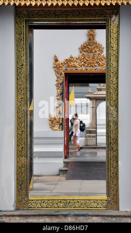 Architektonisches Detail mit Touristen zu Fuß in der Tempelanlage Wat Pho in Bangkok, Thailand. Stockfoto