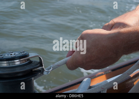 Einholen der Segel auf einem kleinen Vergnügen Segelboot. Stockfoto