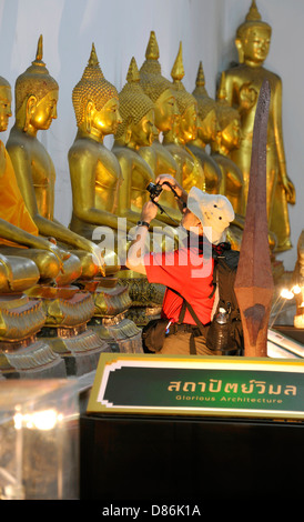 Touristen fotografieren goldenen Buddha-Statuen in der Tempelanlage Wat Pho in Bangkok, Thailand. Stockfoto