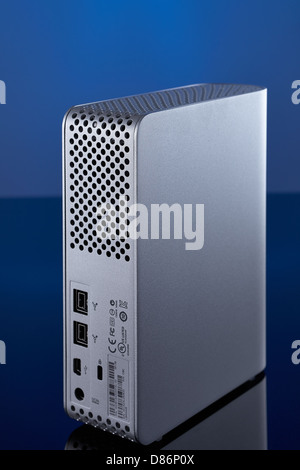 Rückseite einer grauen Farbe externe Festplatte mit blauem Hintergrund. Reflexion an der Unterseite. Stockfoto