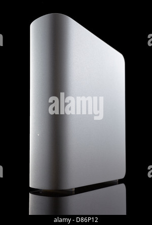 Eine graue externe Festplatte vor schwarzem Hintergrund auf niedrigen Winkel gedreht. Reflexion an der Unterseite. Stockfoto