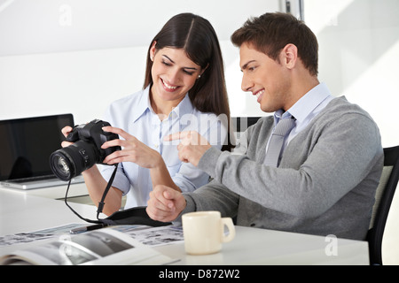 Mann und Frau mit Kamera im Büro sitzen und betrachten von Fotos Stockfoto
