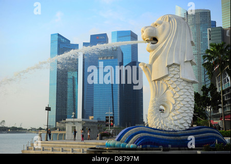 Der Merlion Brunnen Tüllen Wasser vor der Skyline von Singapur. Stockfoto