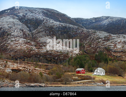 Traditionellen kleinen norwegischen Dorf mit roten und weißen Holzhäusern auf felsigen Küste Stockfoto