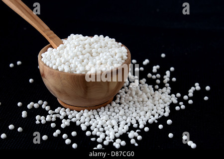 Tapioka-Perlen in kleinen Holz Schüssel auf schwarzem Hintergrund Stockfoto