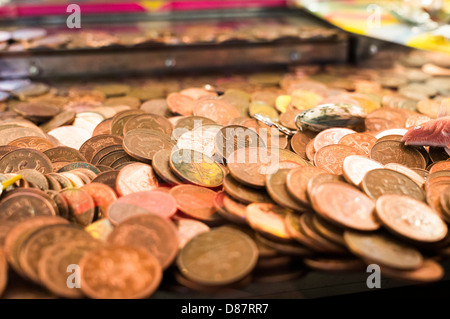 Geld - Stapel von 2p-Stücken in einer Spielautomat mit Spielautomaten, Grossbritannien Stockfoto