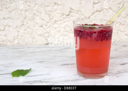 Großes Glas Erdbeer Mojito auf dem Gartentisch außerhalb Stockfoto